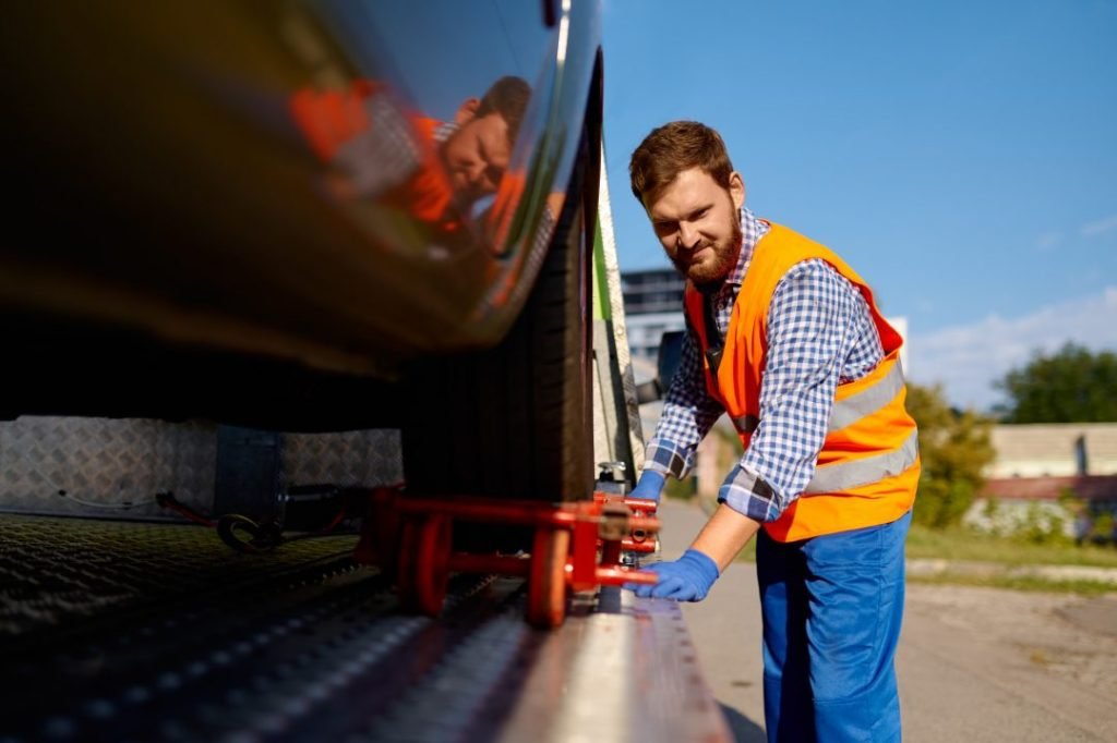 Tow Truck Operator Fixing the Car on Platform